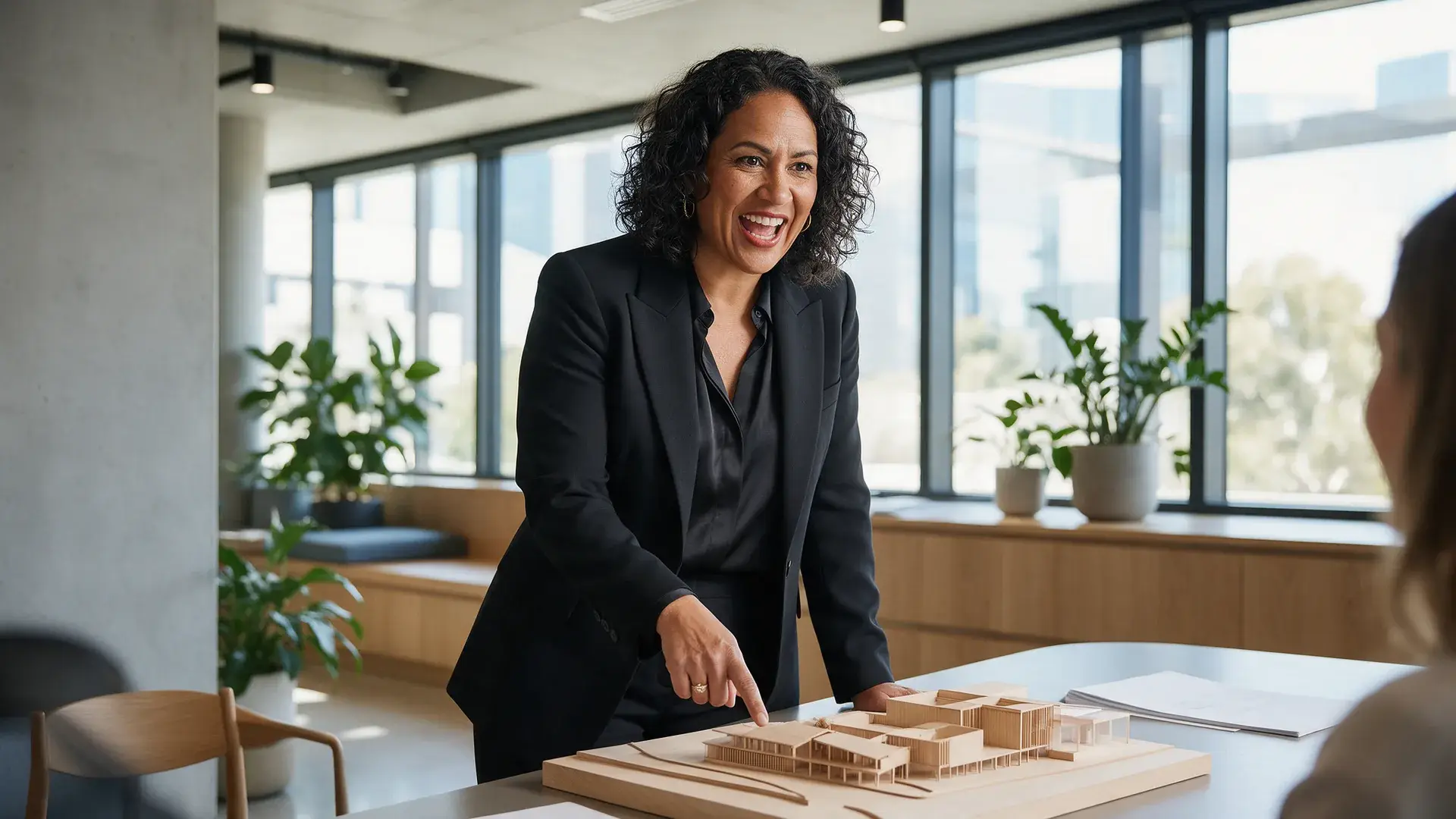 Adelaide design studio founder presenting an architectural model to a client in a light-filled office